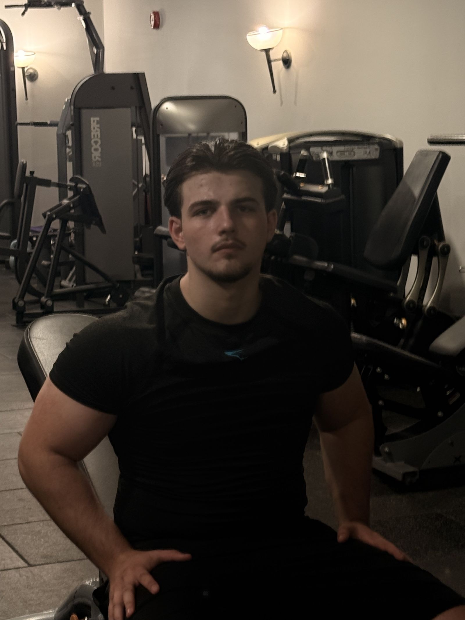 Zak Rickard, personal trainer and founder of Ascendant Fitness, seated in the gym